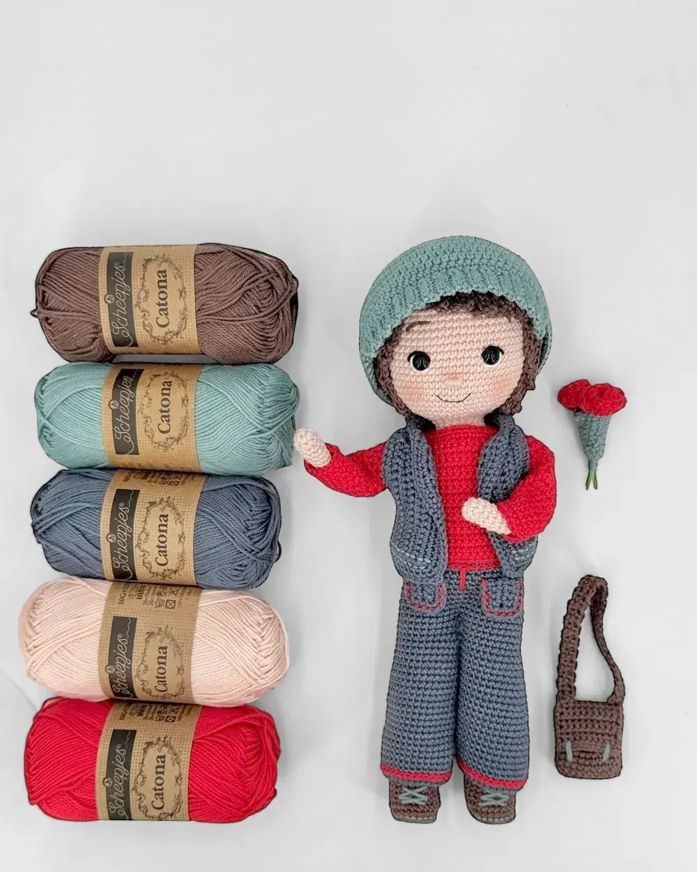 Pelotes de coton à côté de Valentin, la poupée au crochet